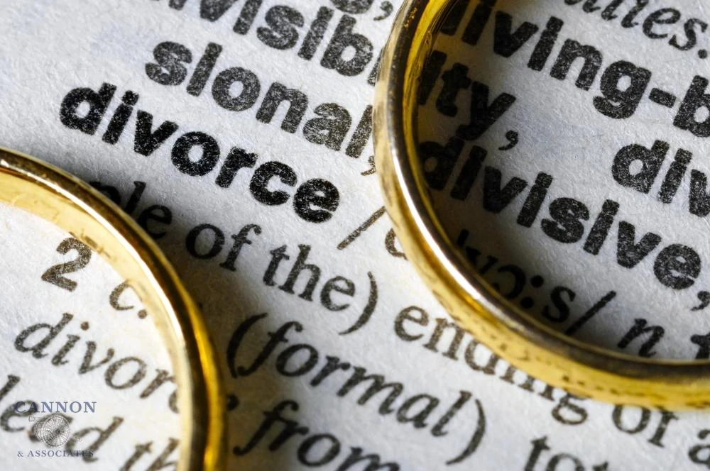 Two wedding rings sitting on top of definition of divorce.