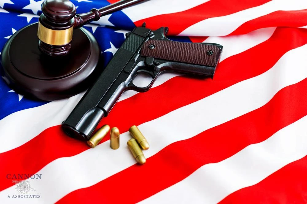 Gun and judge gavel on top of an American flag.
