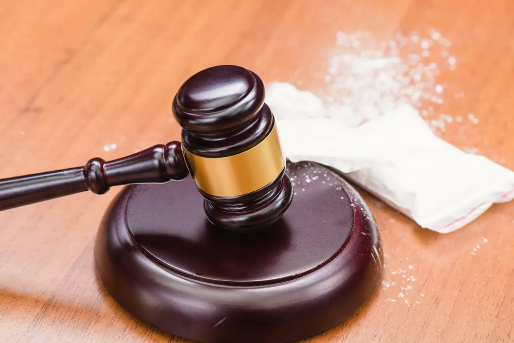 A gavel next to a bag of cocaine.