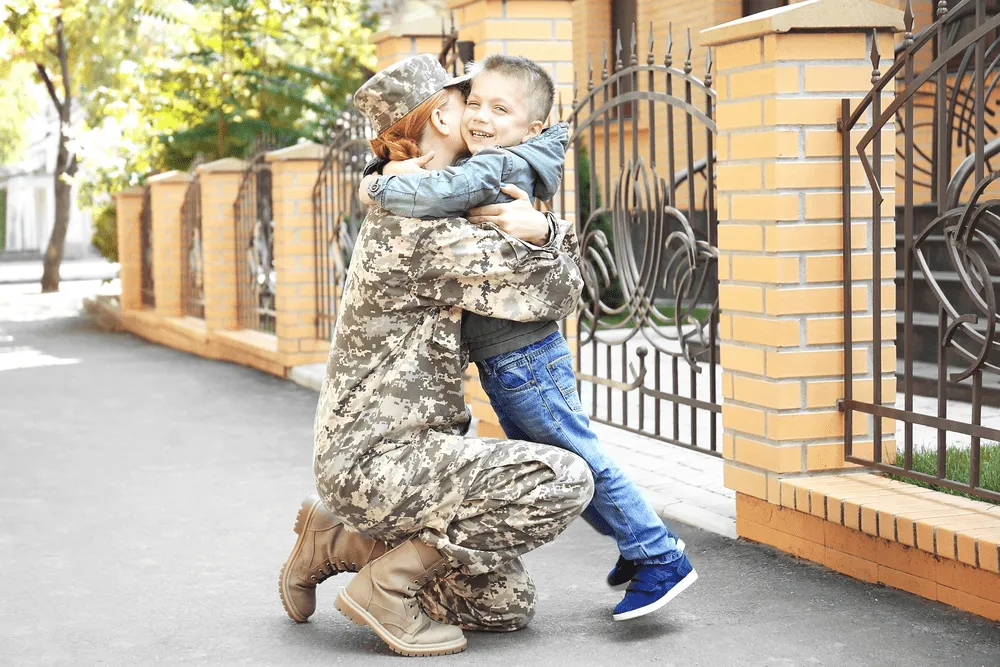 A military woman hugging her son.