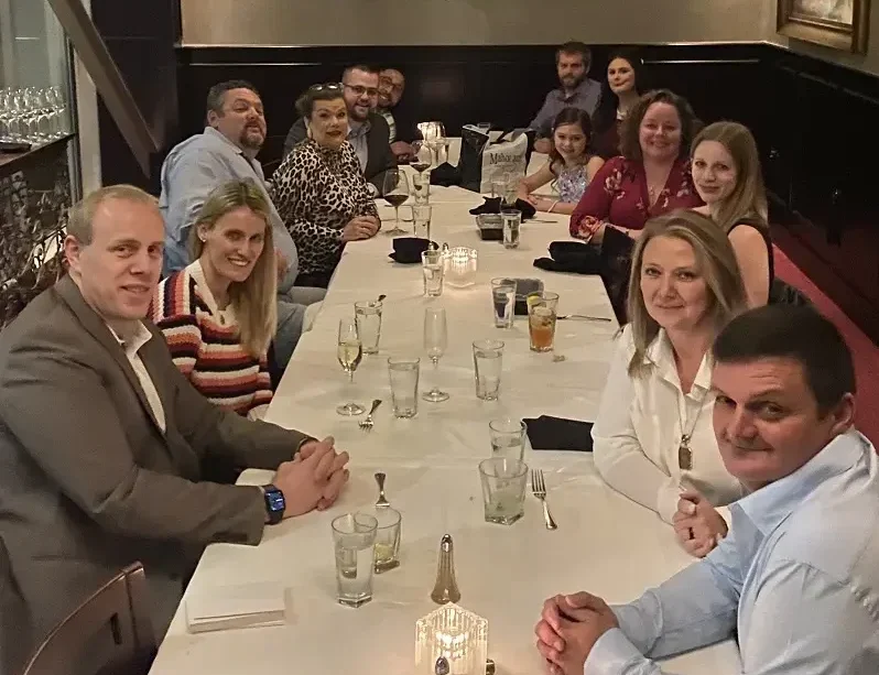 Team photo of firm at dinner.