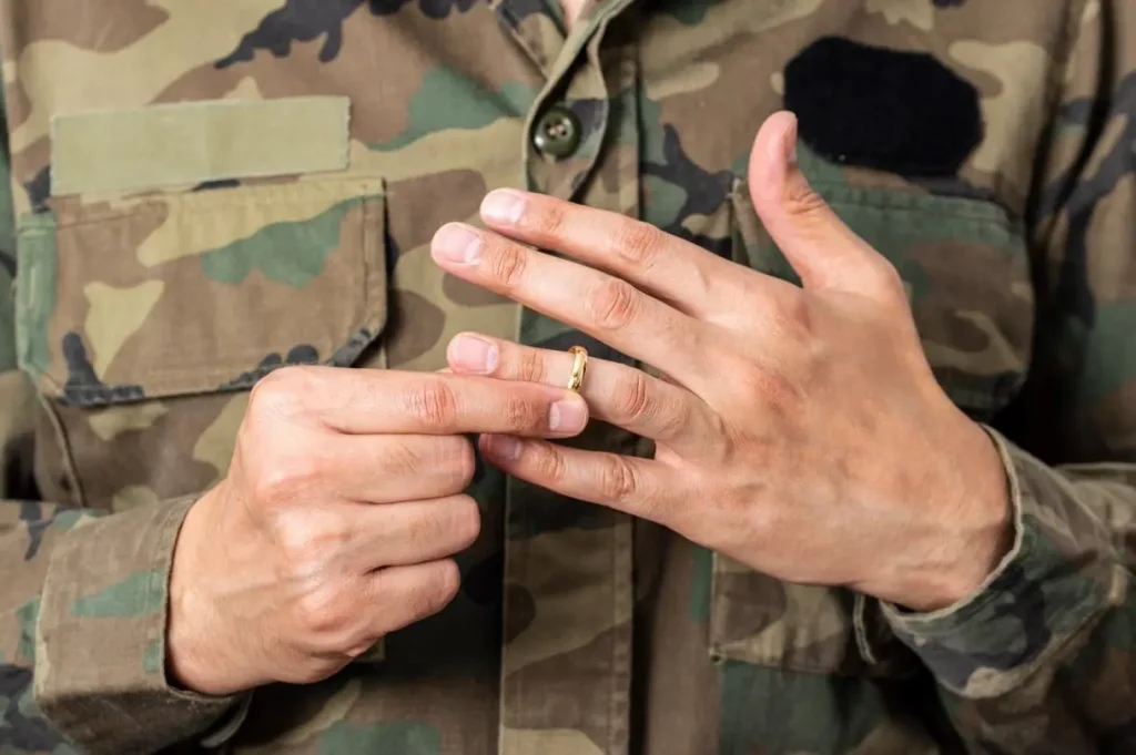 A military man taking off his wedding ring.