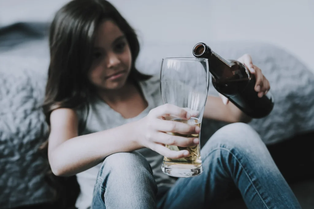 A young girl leaning against a couch drinking alcohol before deciding to drive home. Our Olkalhoma City DUI defense lawyer will fight for minors who have been charged with DUI offenses.