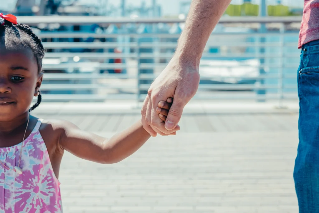 man holding a little girl's hand