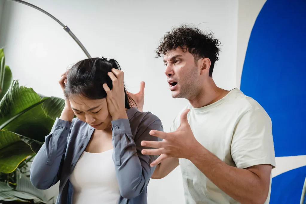 man yelling at woman covering her ears