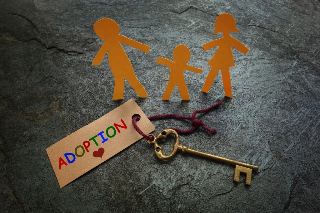 The word adoption tied to a key with cut out family.