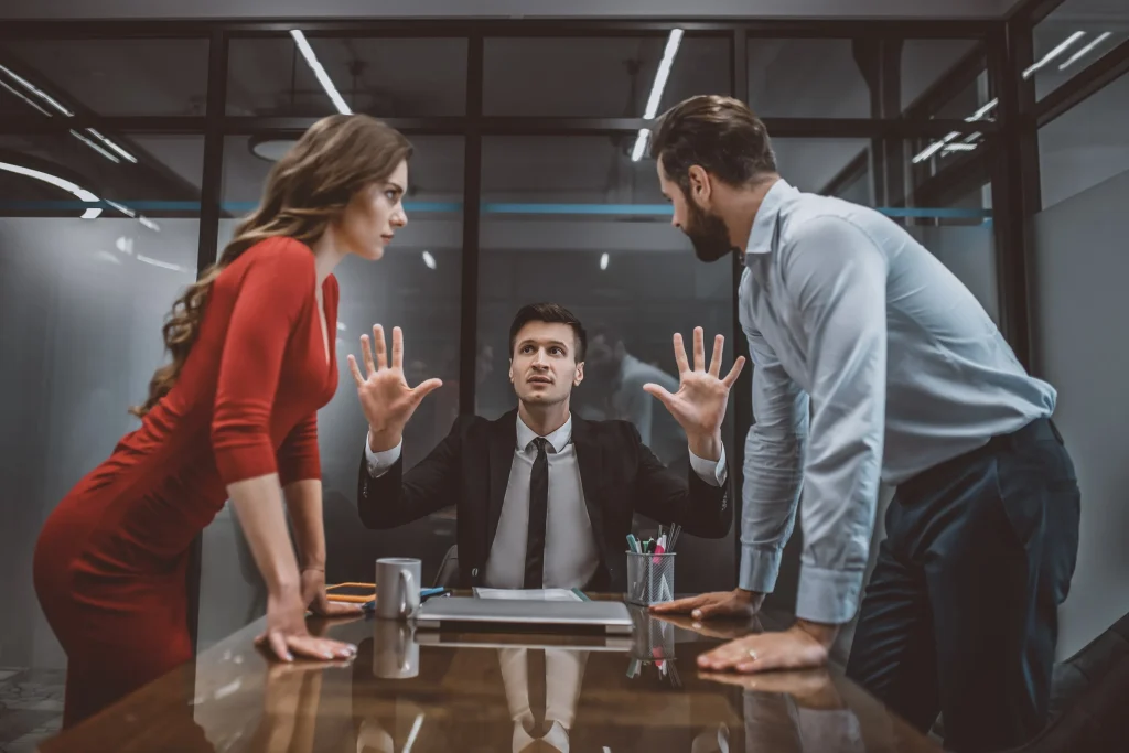 A man and woman arguing in front of a divorce attorney.