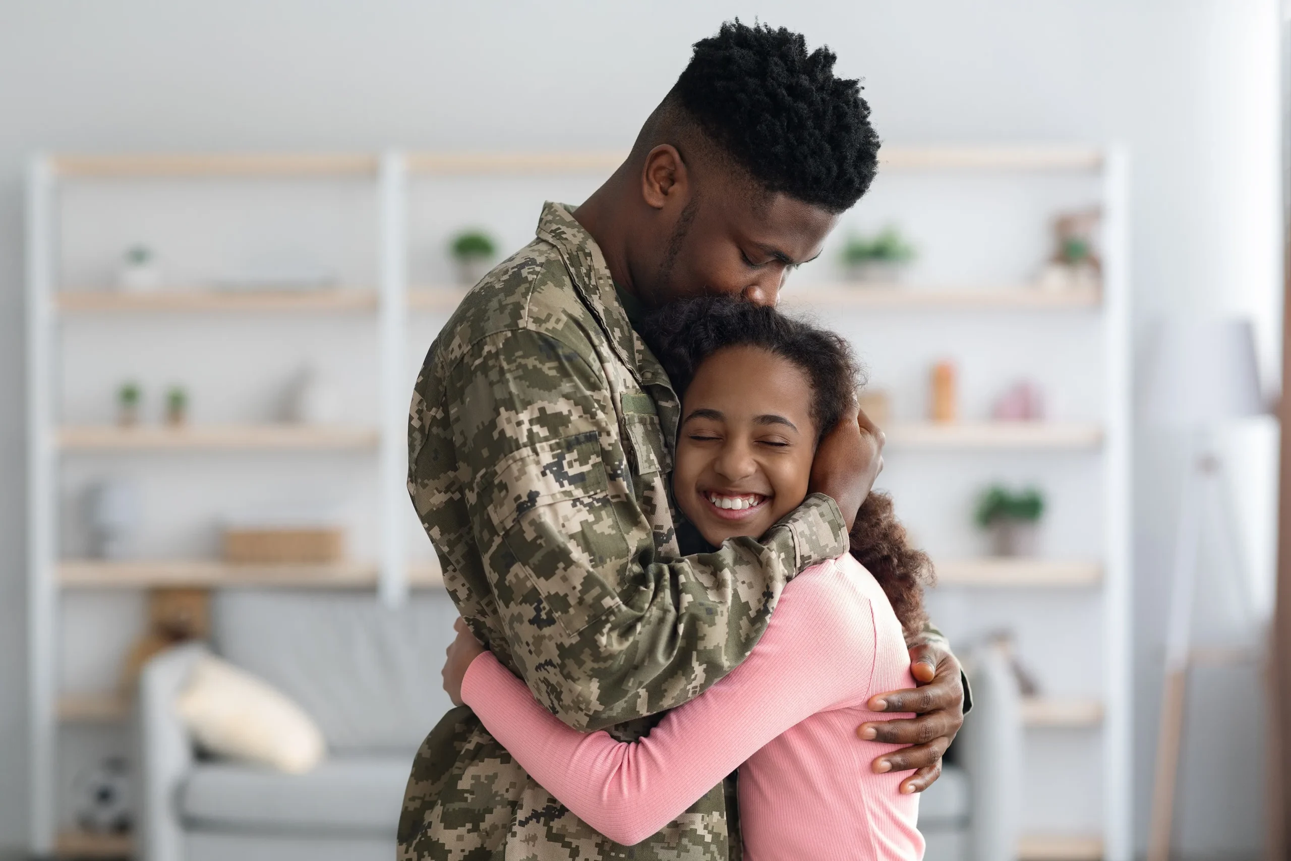 A military man hugging his child.