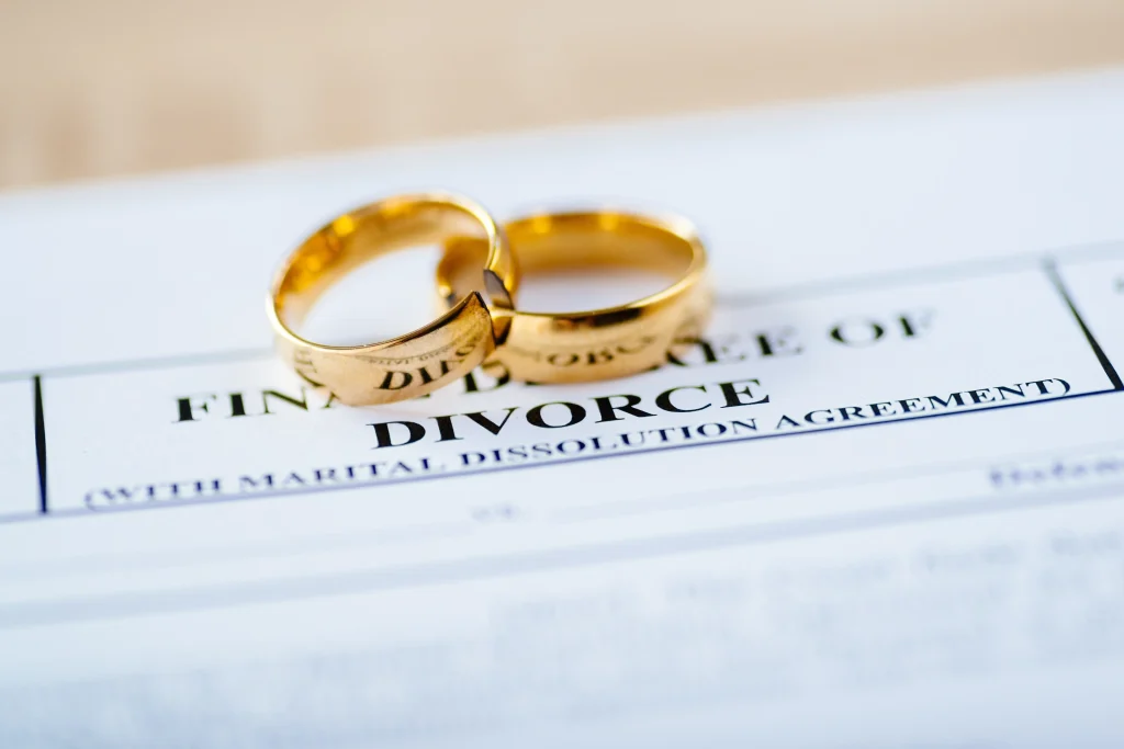 Divorce paperwork with two rings laying on it.