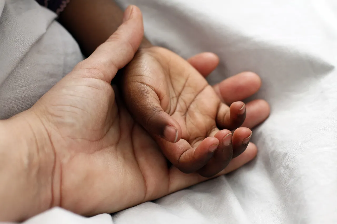 A parent holding their child's hand.