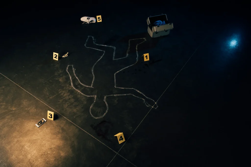 Escena del crimen con el contorno de un cuerpo en el suelo, rodeado de marcadores de evidencia numerados y herramientas forenses.