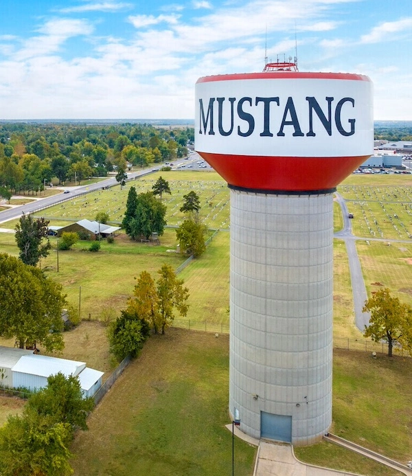 A red and white water tower that says Mustang in Oklahoma