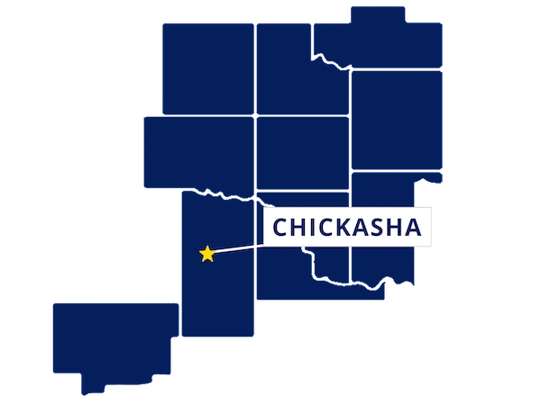 Map highlighting Chickasha, Oklahoma with a yellow star and label, surrounded by outlined counties in dark blue.